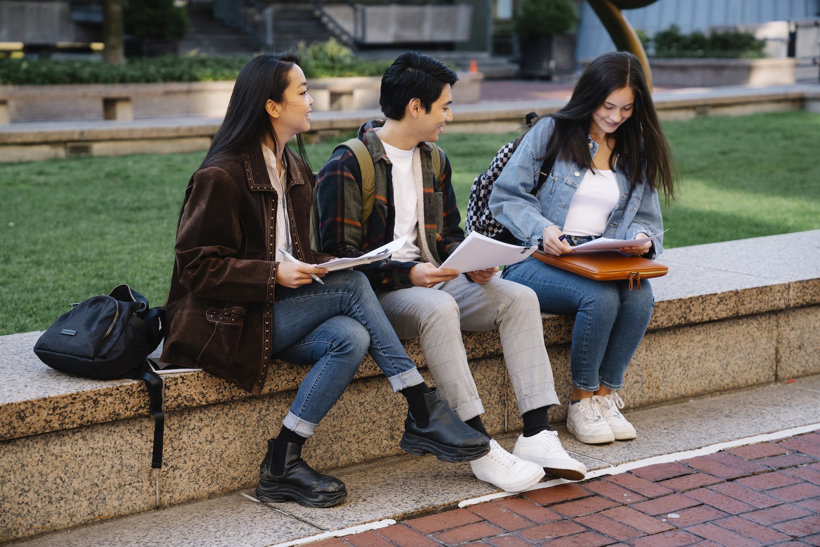 Man and Women Sitting on Brown Concrete Bench discussing their average computer science GPA